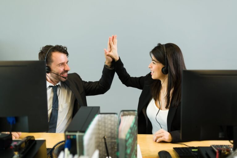 hispanic-man-young-woman-with-headset-doing-high-five-while-working-together-call-center-sales-representative-celebrating-business-sale-min